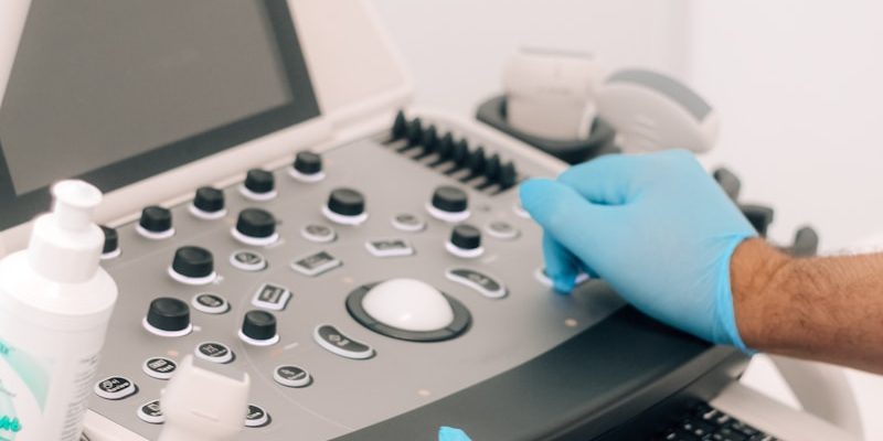 a person in blue gloves is operating a machine